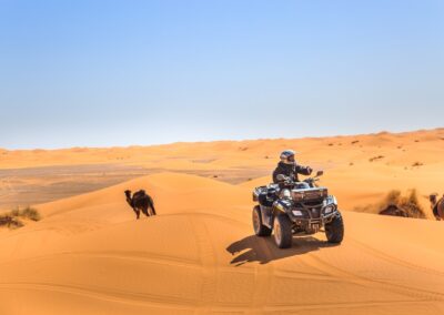Quad biking tour across the golden dunes of Merzouga desert with clear skies Atlas Itinerary