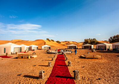 Traditional bivouac camp with Berber tents in the Merzouga desert at sunset Atlas Itinerary
